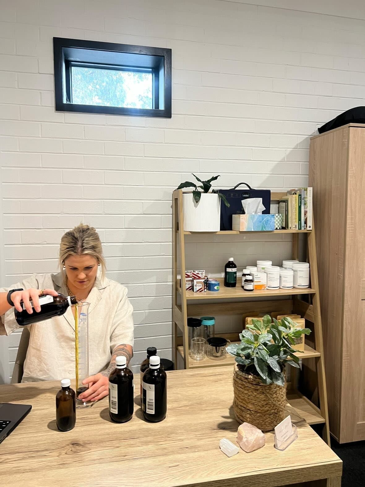 Alanna Cottrill, naturopath, seated at her desk in the clinic.